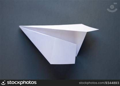White paper plane origami isolated on a blank grey background. White paper plane origami isolated on a grey background