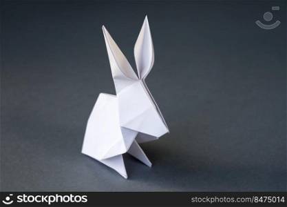 White paper rabbit origami isolated on a blank grey background.. White paper rabbit origami isolated on a grey background