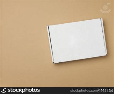 white paper rectangular box on beige background, top view