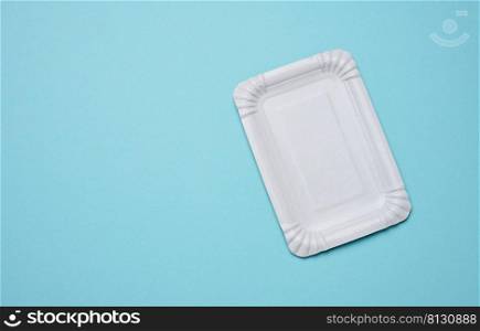White paper rectangular plate on a blue background, top view. Copy space