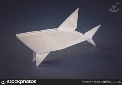 White paper shark origami isolated on a blank grey background. White paper shark origami isolated on a grey background