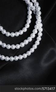 white pearl necklace on a black silk close up