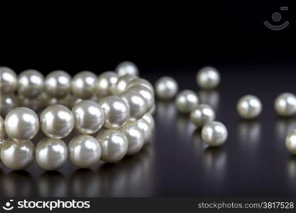 white pearls necklace on black background