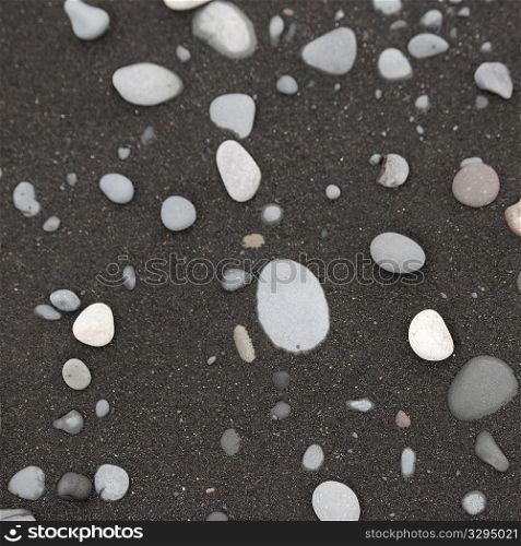 White pebbles on black sand