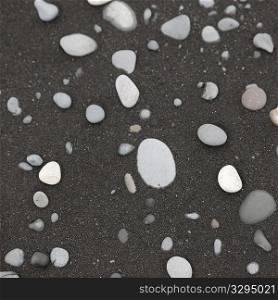 White pebbles on black sand