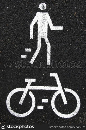 white pedestrian and bicycle road signs painted on the asphalt surface