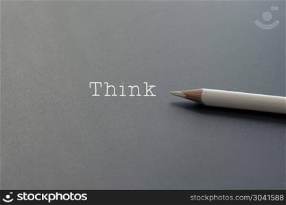 white pencil on black backgrounds with text Think and copy space