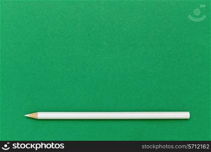 White pencil on green background
