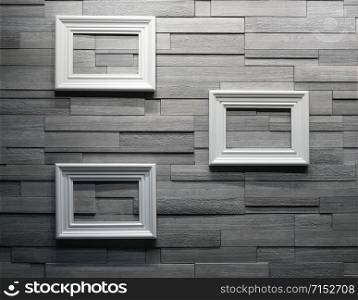 White picture frames mounted on a wooden wall. Design composition of home interior.