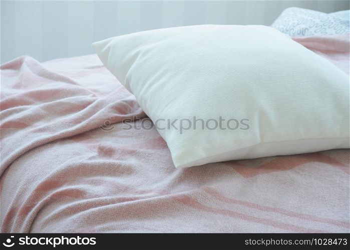 White pillow on pink messy bed