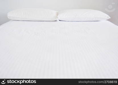 White pillows and bed in white bedroom