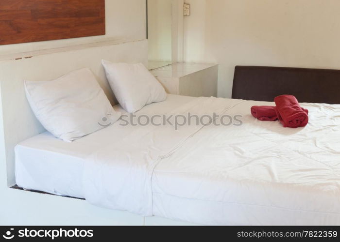 White pillows and bed linen. There are two pieces of red cloth on the bed. Koh Samet.