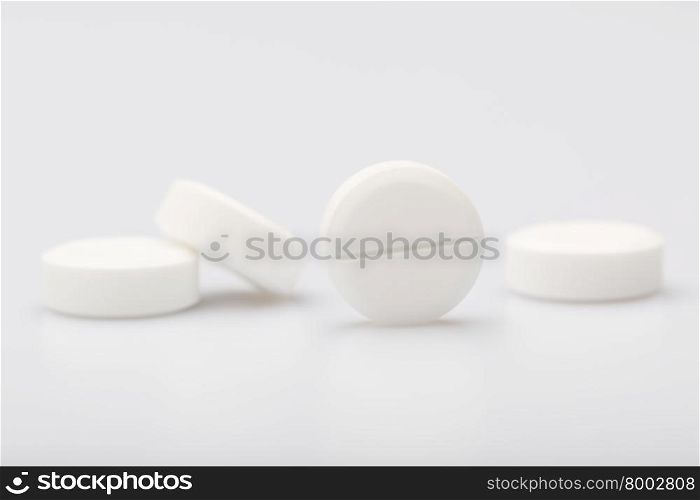 White pills on a white background. White round pills on a white background