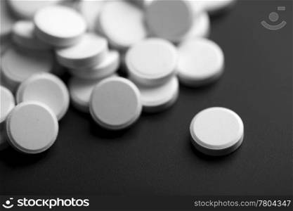 white pills over black background