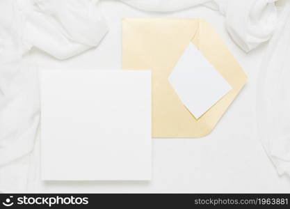 white placard near yellow envelope with scarf white backdrop. High resolution photo. white placard near yellow envelope with scarf white backdrop. High quality photo