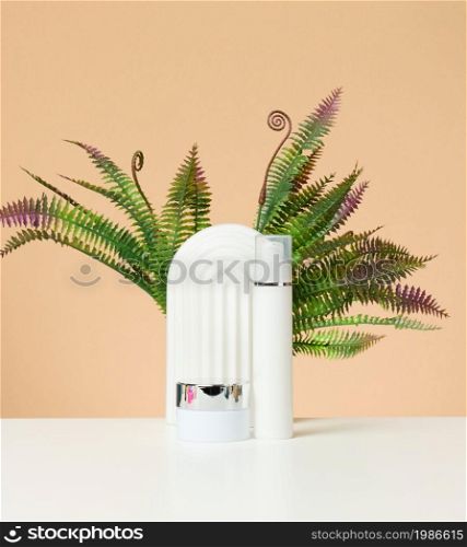 white plastic bottle and jar for cosmetics on a white table. Packaging for cream, gel, serum, advertising and product promotion, mock up