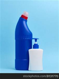 White plastic bottle with dispenser and blue plastic bottle for chemical detergents on a blue background