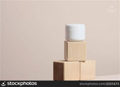 white plastic jar for cosmetics on a beige table. Packaging for cream, gel, serum, advertising and product promotion, mock up