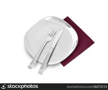 White plate, fork and knife on brown napkin. Isolated on white. With clipping path