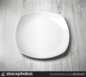 white plate on wooden background close up