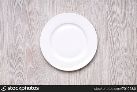 white plate on wooden table background top view