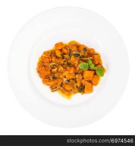 White plate with pumpkin in curry sauce. Studio Photo. White plate with pumpkin in curry sauce