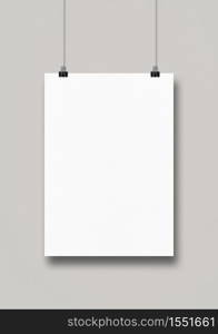 White poster hanging on a clean wall with clips. Blank mockup template. White poster hanging on a clean wall with clips