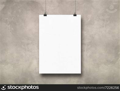 White poster hanging on a light concrete wall with clips. Blank mockup template. White poster hanging on a light concrete wall with clips