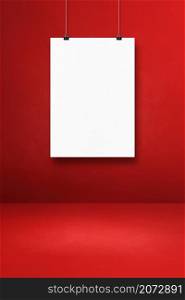 White poster hanging on a red wall with clips. Blank mockup template. White poster hanging on a red wall with clips