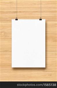 White poster hanging on a wooden wall with clips. Blank mockup template. White poster hanging on a wooden wall with clips
