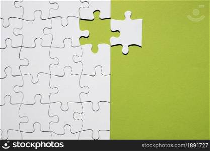 white puzzle piece separate with white puzzle grid green backdrop. Resolution and high quality beautiful photo. white puzzle piece separate with white puzzle grid green backdrop. High quality and resolution beautiful photo concept