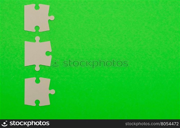 White puzzle pieces isolated on a green background
