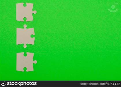 White puzzle pieces isolated on a green background