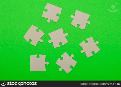 White puzzle pieces isolated on a green background