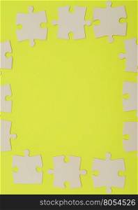 White puzzle pieces isolated on a yellow background
