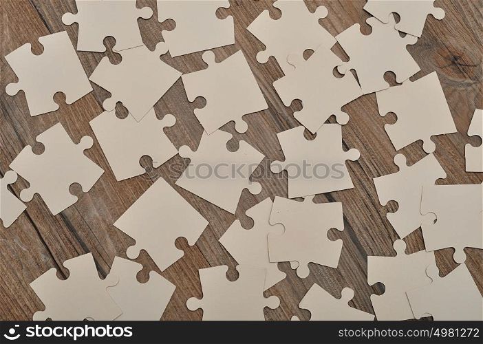 White puzzle pieces on a wooden background