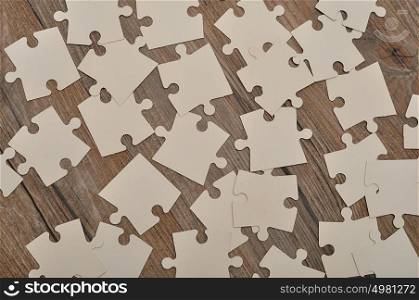 White puzzle pieces on a wooden background
