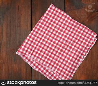 white red checkered kitchen towel on a brown wooden background, picnic background, copy space