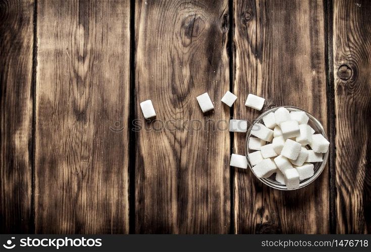 White refined sugar in the Cup. On wooden background.. White refined sugar in the Cup.