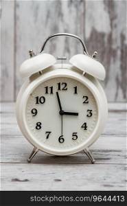 White retro alarm clock on white wooden background