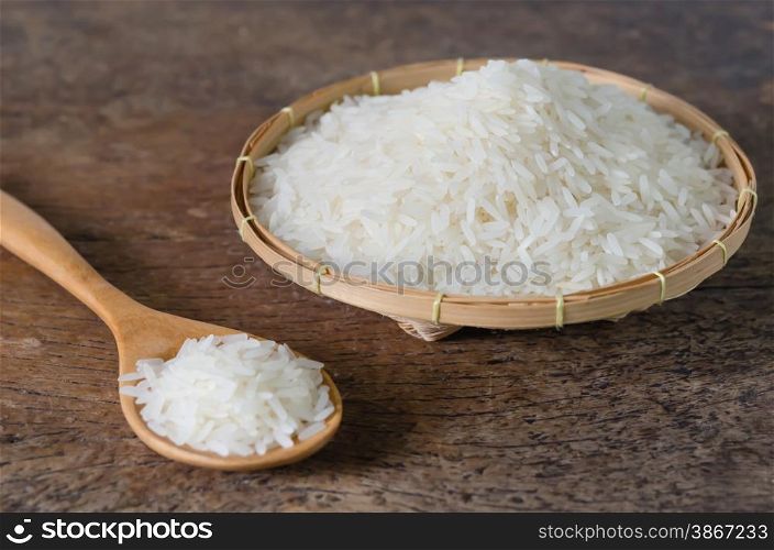 white rice grains. white rice grains with wooden spoon on wooden table