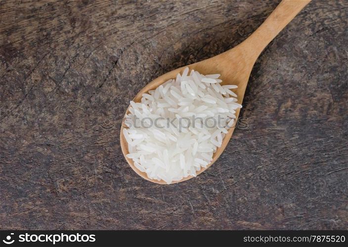 white rice grains. white rice grains with wooden spoon on wooden table
