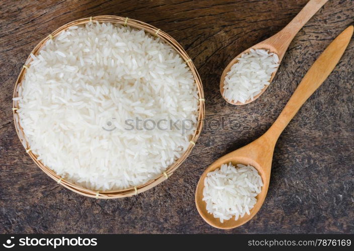 white rice grains. white rice grains with wooden spoon on wooden table