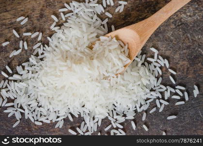 white rice grains. white rice grains with wooden spoon on wooden table