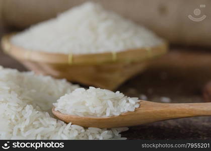 white rice grains. white rice grains with wooden spoon on wooden table