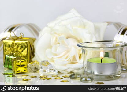 white rose, gift boxes and green burning candle