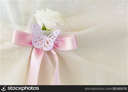 White rose with pink ribbon and paper butterfly