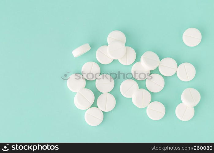 White round tablets close-up on a colored background. White round pills close-up on a colored background