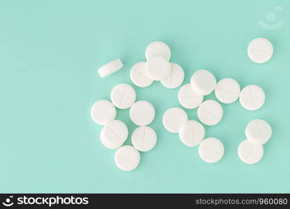 White round tablets close-up on a colored background. White round pills close-up on a colored background