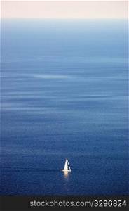 White sailboat sailing on clear blue sea